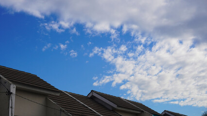 House roof tiles or roof top of residential house with Blue sky and dense white clouds on a sunny...