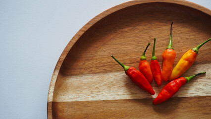 Isolated flat lay cayenne pepper or Capsicum annuum also commonly called Birds Eye on a wooden tray. Selective focus                            