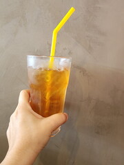 Bael fruit juice, Longan juice or Chrysanthemum juice with ice and yellow tube. Hand holding cold...
