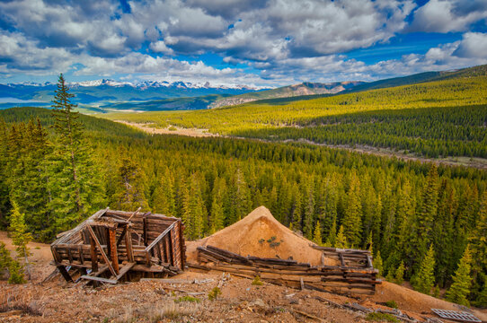 The image captures the essence of Colorado's heartland featuring the stunning nature, mountains, and remnants of an old structure as a testament to times past