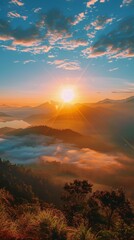 Golden sunrise peaking over cloud-covered mountains with rays illuminating the sky and landscape
