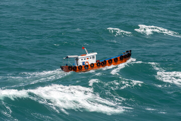 The Asian boat of the pilot in the high sea during a storm.