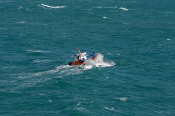 The Asian boat of the pilot in the high sea during a storm.