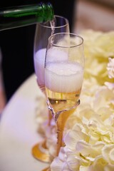 Festive drinks glasses for the newlyweds on the background of the wedding cake. The wedding table.