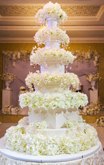 Confectionery for the festive table. A big wedding cake. Decoration of marzipan and fresh flowers