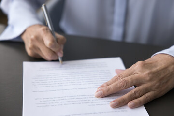 Older female hand signing business document, putting signature on legal paper, making commercial...