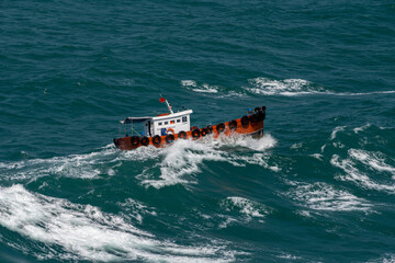 The Asian boat of the pilot in the high sea during a storm.