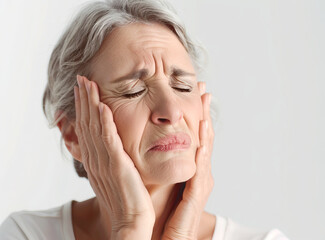 Distressed Elderly Woman Touching Temples Suffering from a Headache on light background