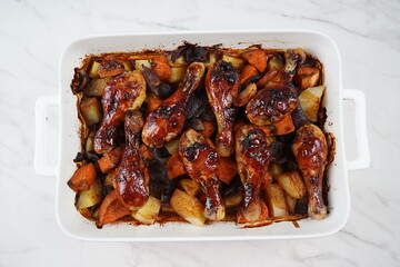 Roasted chicken legs with potatoes, sweet potato, red onion
