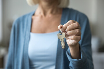 Close up cropped view unknown mature woman realtor showing to camera bunch of keys, make profitable...