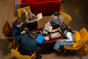 top shot in large beautiful hall office employees sitting on yellow chairs discuss a deal