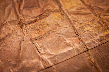 Extreme closeup of crumpled brass foil texture