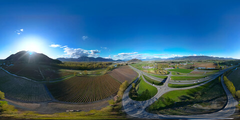 360 Aerial View of the Farms and Mountains. Dramatic Sunny Sunset Sky.