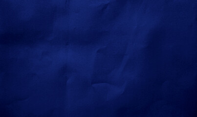 close up crumpled dark blue kraft paper background showing crease texture with blank space for...