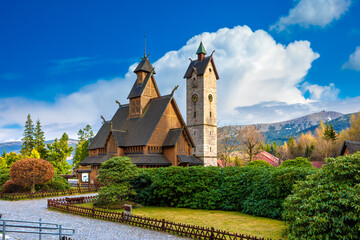 Medieval Norwegian stave wooden church Vang or Wang in summer and Snezka mountain in the background. Church was transferred from Vang in Norway to Karpacz in 1842. Karpacz, Poland - obrazy, fototapety, plakaty