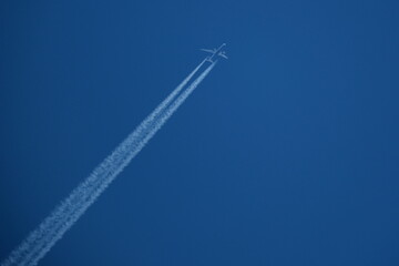 Airplane in the blue sky with contrail