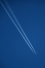 Airplane in the blue sky with contrail