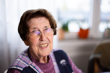 authentisches Portrait einer 90 jährigen Seniorin zuhause im Wohnzimmer - obrazy, fototapety, plakaty