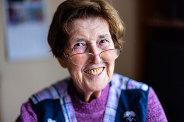 authentisches Portrait einer 90 jährigen Seniorin zuhause im Wohnzimmer - obrazy, fototapety, plakaty