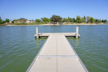Fototapeta na wymiar Double sided boat dock stretching into cool spring waters of Kiwanis park lake, Tempe, Arizona 