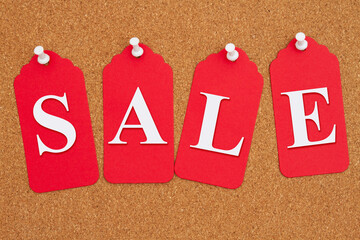 Sale message on red gift tags on a corkboard - 783873474