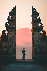 Young Man Silhouette Standing At Balinese Gate In Lempuyang Temple Watching Mount Agunt At The...