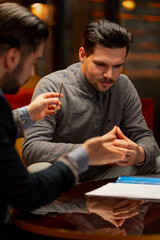 Fototapeta premium close up in the office sitting in yellow chairs two male entrepreneurs enter into agreement signing documents