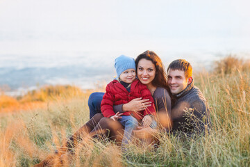 Portrait of the little girl with a funny hat and father and mother smiling outdoors