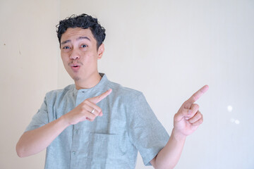 Moslem Asian man pointing the link gesture when Ramadan celebration. The photo is suitable to use...