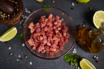 Sliced and chopped tuna fillet in glass bowl at domestic kitchen cooking traditional tartare