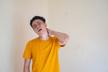 Young man wear yellow t-shirt with sleepy pose expression gesture. The photo is suitable to use for man expression advertising and fashion life style.