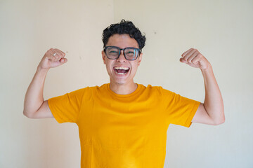 Young man wear yellow t-shirt with strong pose expression gesture. The photo is suitable to use for...