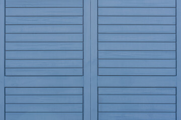 blue wooden wall with sections and vertical and horizontal boards