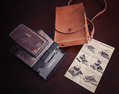 Antique and worn Polaroid Sx-70 analog folding instant land camera with the original leather holding bag