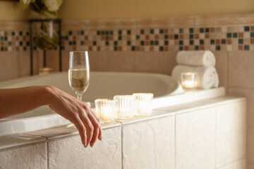 Woman Relaxing in the Bathroom Spa Tub with a Glass of Sparkling Champagne and Candles. - 783895430