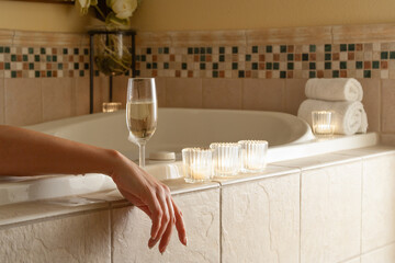 Woman Relaxing in the Bathroom Spa Tub with a Glass of Sparkling Champagne and Candles. - 783895476