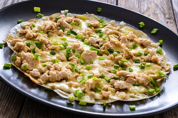Vietnamese pizza - rice pepper omelet with chicken meat and mushrooms on wooden table
