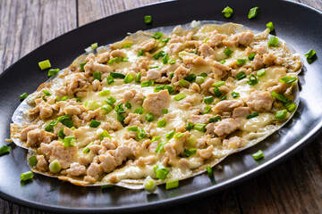 Vietnamese pizza - rice pepper omelet with chicken meat and mushrooms on wooden table
