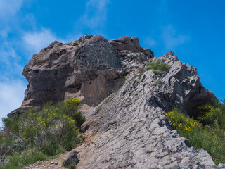 Fototapeta na wymiar View of rocky top of Pico Grande one of the highest peaks in the Madeira over blue sky. Mountain landscape at hiking trail PR12, Madeira, Portugal
