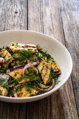 Marinated herring fillets with dill and red onion on wooden table
