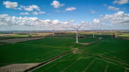 Turbine Windmills wind farm in rural England. Renewable energy. Beautiful sunny day.
