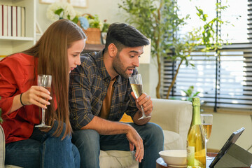 Amidst holiday decorations, a couple shares a cheerful toast with flutes of bubbly, reveling in the...