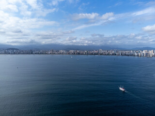 large coastal city seen from the sea with building and many clouds