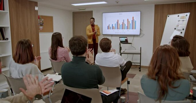 Employees enthusiastically clap hands, applauding during a seminar focused on business development and skill enhancement, showing appreciation for the valuable insights and knowledge shared.