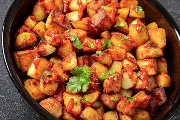 fried spanish potatoes with paprika sauce in bowl