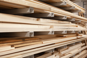 Stacked wood boards for machinery. Pine board beams stacked and organized at warehouse. - obrazy, fototapety, plakaty