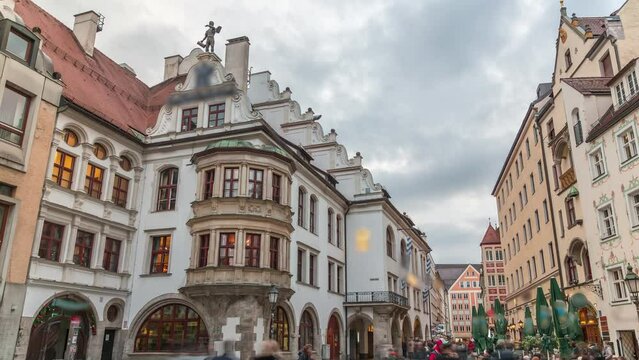 Cityscape with bier houses and restaurants outdoors on Platzl timelapse in Munich, Bayern, Germany. Walking area with tables and chairs. People relaxing in cafes