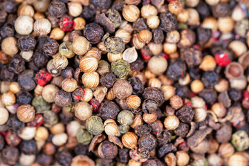 Set of peppercorns of different species and colors arranged in a disorderly