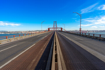 Central and frontal perspective without car traffic of the 25 de Abril bridge in the direction Almada-Lisboa-Portugal.