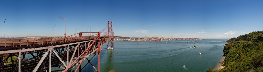 Side view of the 25 de Abril bridge towards Almada-Lisboa with the Tagus River on the right and the capital of Portugal.Almada-Portugal.
